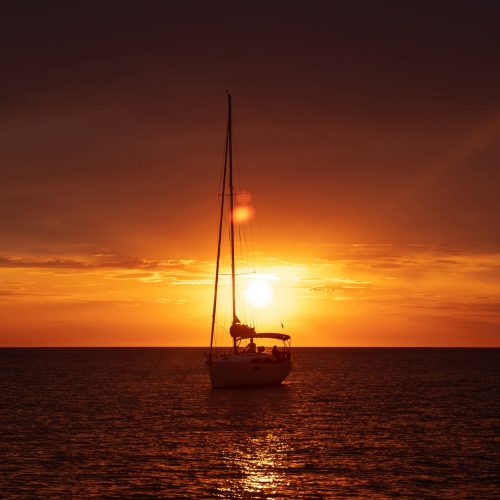 Aerial view from drone on boat shipping in sea, sunset. Yachting with a dramatic sunset as backdrop
